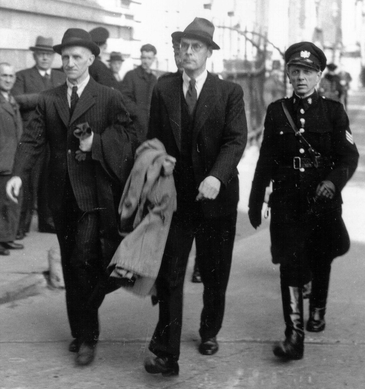 3 Männer schreiten auf Straße